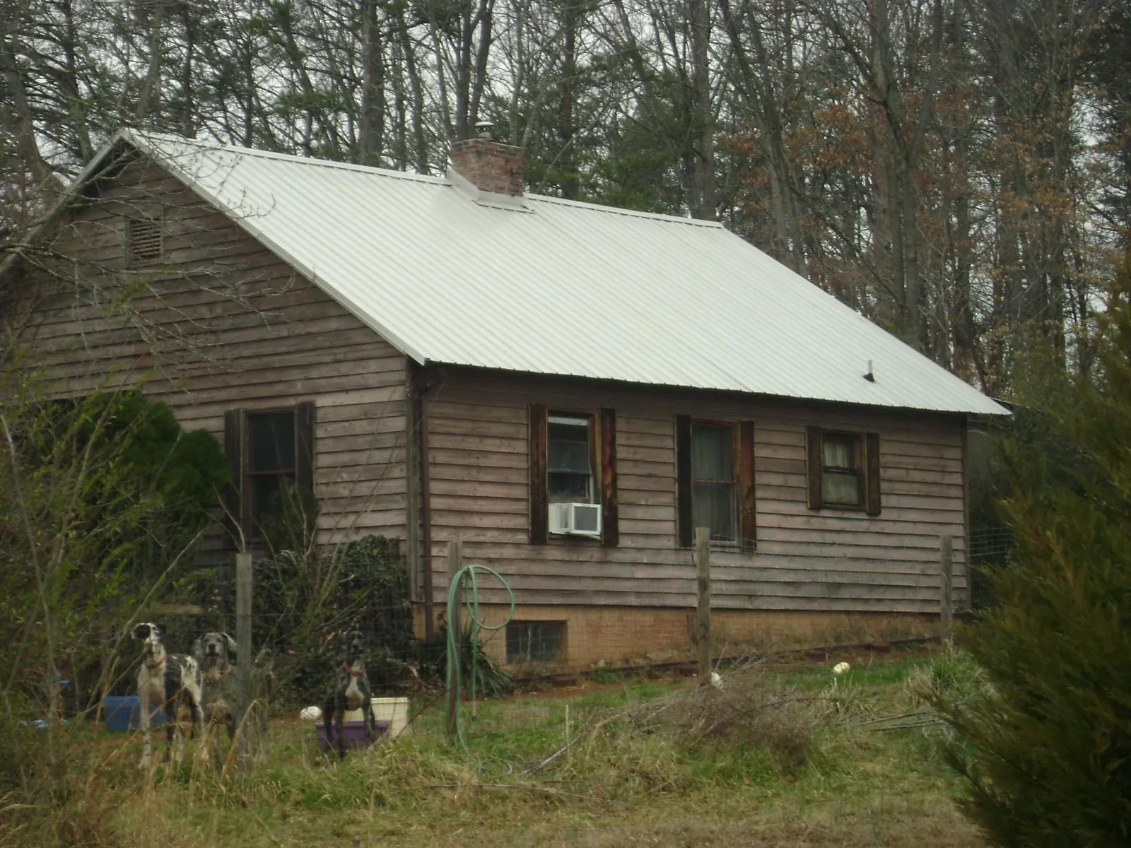 White metal roof on an old wood sided farmhouse, from a Metal Roof Installation job in Cibolo